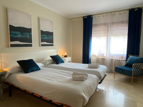 2 camas en una habitación con cortinas azules en Las Casas de Sofía, en Cabanillas