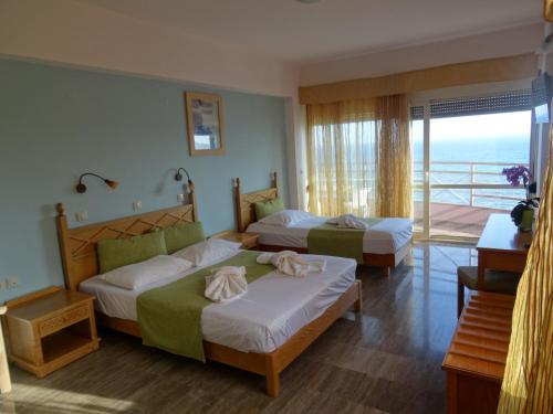 een hotelkamer met 2 bedden en een balkon bij Thalassa House Apartments in Plakias