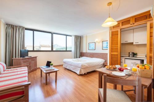 a hotel room with a bed and a kitchen at Apartamentos Carlos V in Alcudia