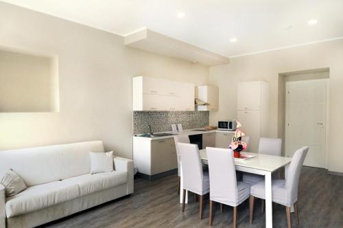 a living room with a white couch and a table and chairs at Hotel Alexander & Spa in Sanremo