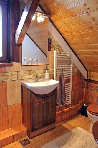 a bathroom with a sink and a wooden ceiling at Casa Crina in Sălişte