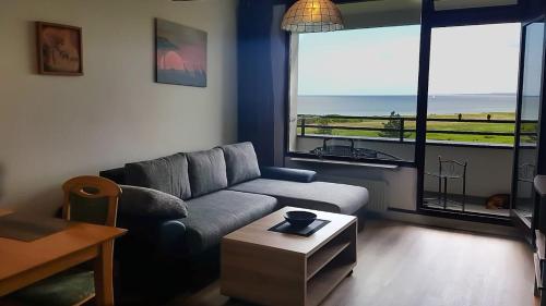 a living room with a couch and a table at Ferienwohnung mit Meerblick in Damp