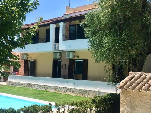 a house with a swimming pool in front of it at Villa-Toula in Roda