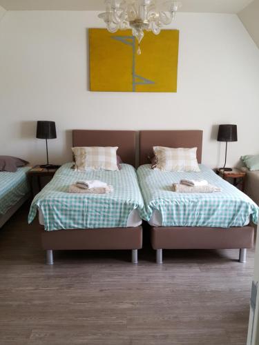 dos camas sentadas una al lado de la otra en una habitación en B&B Villa Vanilla, en Ypres