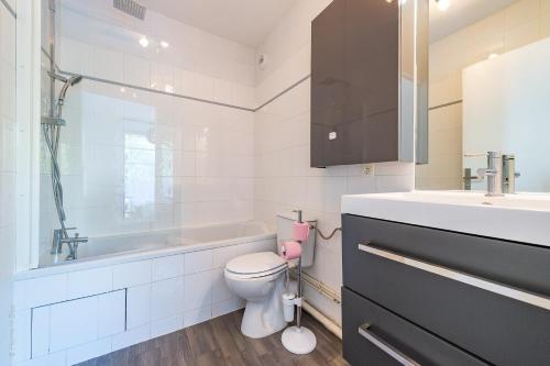 a white bathroom with a toilet and a sink at Cozy Corner in Montévrain
