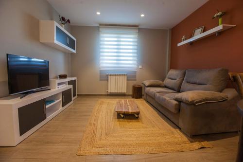 a living room with a couch and a flat screen tv at Endaneta Berri in Zumaia