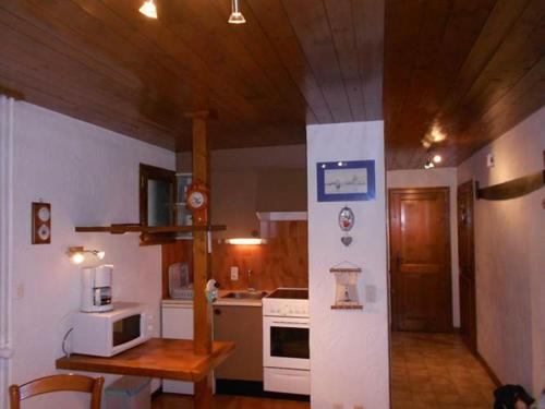 uma cozinha com electrodomésticos brancos e um tecto de madeira em Chalet de Basseville em Combloux