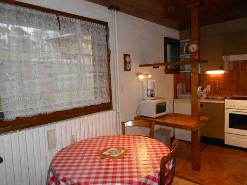 uma cozinha com uma mesa com uma toalha de mesa xadrez vermelha e branca em Chalet de Basseville em Combloux