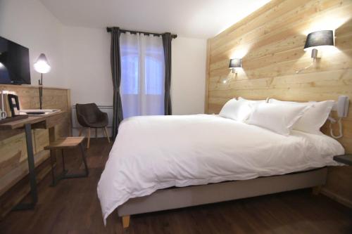 a bedroom with a large white bed and a desk at Hotel SNOW CHILL in Risoul