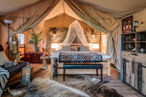 a bedroom with a bed in a tent at Glamping Safari - Africa House in Zlín
