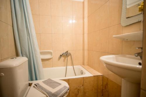 een badkamer met een bad, een wastafel en een toilet bij Eriphilly Studios & Apartments in Mithimna