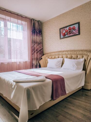een slaapkamer met een bed met witte lakens en een raam bij 2 к квартира рядом стадион Металлист м. Спортивная. in Charkov