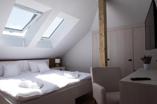 1 dormitorio con 1 cama, 1 silla y 1 ventana en Apartamenty Ach To Tu en Mikołajki