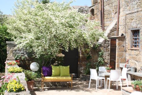 a patio with a table and chairs and a tree at L'Incanto di Civita in Bagnoregio