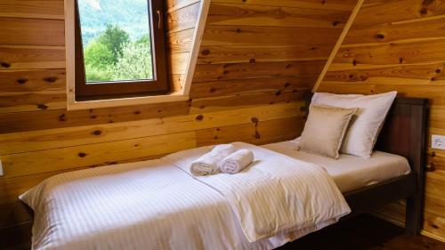 a bedroom with a bed with two towels on it at FERN FARM ECO RESORT in Mojkovac