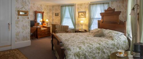 Schlafzimmer mit einem Bett, einem Schreibtisch und einem Schreibtisch in der Unterkunft The Bridges Inn at Whitcomb House B&B in Swanzey