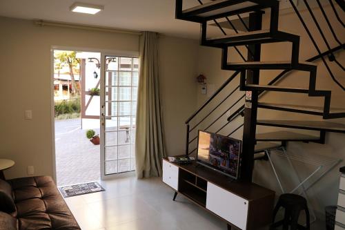 uma sala de estar com uma escada em espiral e um sofá em POUSADA GERMÂNICA em Marcelino Ramos