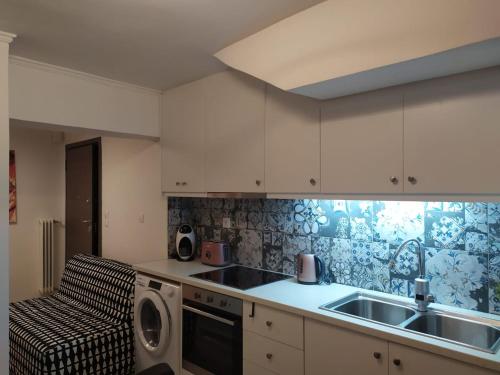 a kitchen with a sink and a washing machine at NEW stylish comfortable basement loft-like apartment in Athens