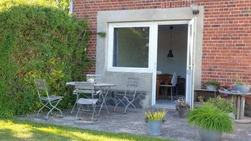 a patio with a table and chairs and a window at Ferienwohnung Erdgeschoss in Fehmarn