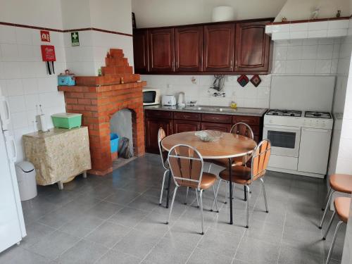a kitchen with a table and chairs and a fireplace at Casa do Povo in Gomes Aires