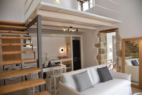 a living room with a white couch and a kitchen at LAINI LUXURY SUITES in Pómbia