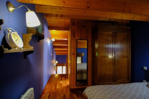 een slaapkamer met een bed en een blauwe muur bij Vallespin Suite in Avila