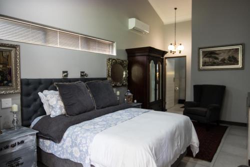 a bedroom with a large bed and a chair at 64 on Malabor in Pretoria