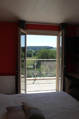 um quarto com uma cama e uma porta de vidro deslizante em Gîte de la Vallée des Dames em Juvigny-sur-Loison