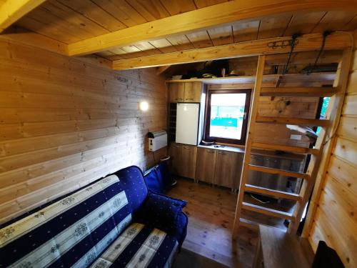 a room with a bench and a ladder in a cabin at Niewygodny Domek z własnym podwórkiem in Wisełka