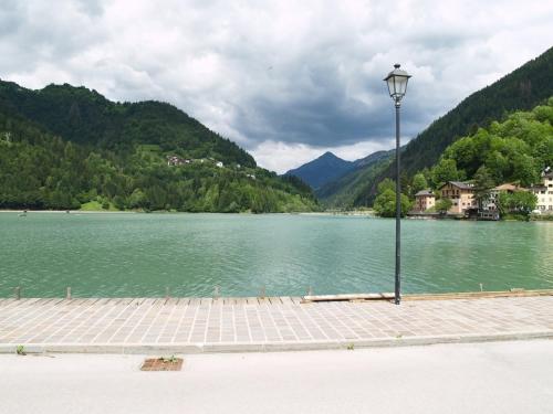 a street light next to a lake with mountains at Appartamenti Katinanna in Alleghe