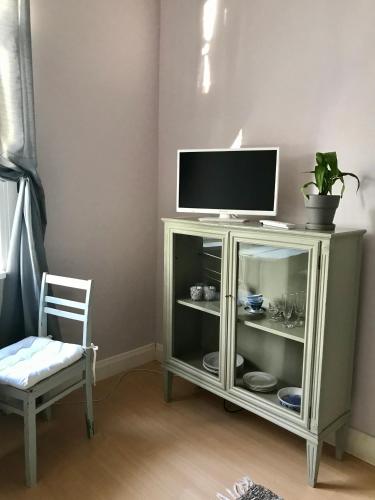 a tv sitting on top of a cabinet with a chair at Willa Strand in Kristiinankaupunki