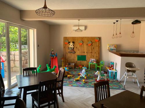 a living room with a table and a play room with toys at Matej in Budva