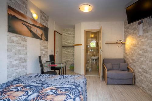 een slaapkamer met een bed, een stoel en een tafel bij DOMINO - pokoje i apartamenty in Szklarska Poręba