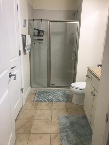a bathroom with a shower with a toilet and a rug at Ocean Front condo in the heart of Hampton Beach in Hampton