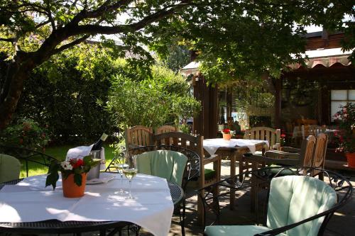 an outdoor restaurant with tables and chairs and trees at Hotel Auhof in Schruns-Tschagguns