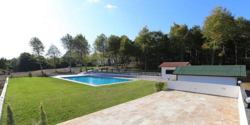 a large yard with a swimming pool and a house at Yıldız Country Hotel in Sinop