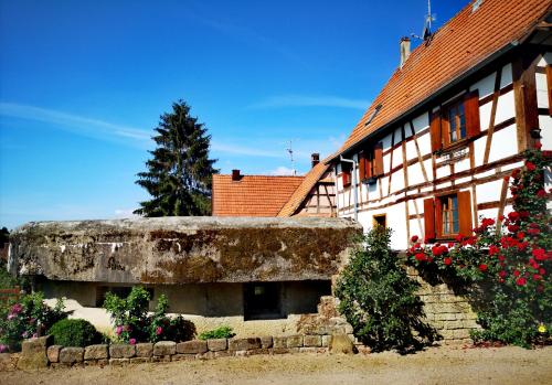 un vieux bâtiment avec des fleurs devant lui dans l'établissement Au Bunker 67, à Rott