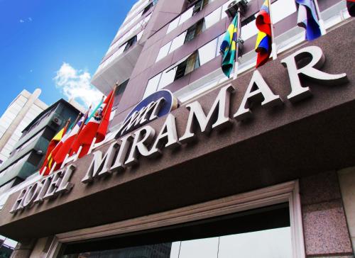 una señal en el lateral de un edificio con banderas en Hotel Miramar, en Lima