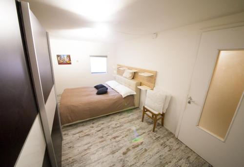 ein kleines Schlafzimmer mit einem Bett und einem Stuhl in der Unterkunft Maison Ville d'Aoste in Aosta