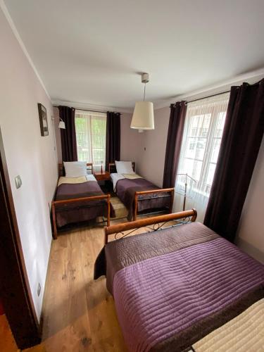 a room with three beds and a window at Apartament Przy Długosza in Sandomierz