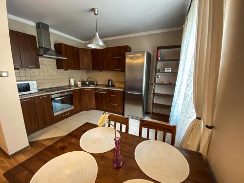 een keuken met een tafel met 2 stoelen en een vaas bij Apartament Przy Długosza in Sandomierz
