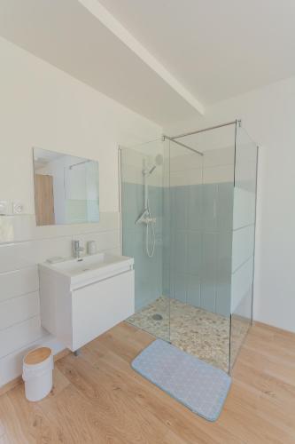 a bathroom with a glass shower and a sink at Villa Bellevue in Ambleteuse