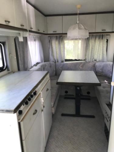 a kitchen with a table in an rv at Przyczepy Kemping Polaris Półwysep Helski in Chałupy