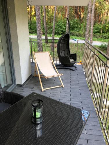 a patio with two chairs and a table on a balcony at Apartament Leśny No 4 Blue in Kielce