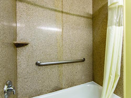 a bathroom with a bath tub with a shower curtain at La Quinta by Wyndham Houston New Caney in New Caney