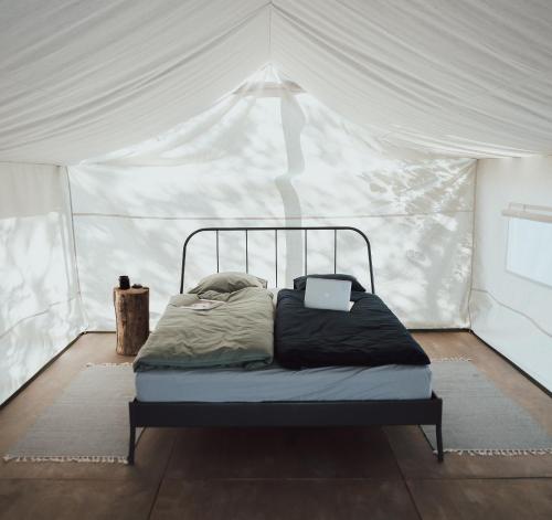 - un lit dans une tente avec un ordinateur portable dans l'établissement Uz salas, à Dagda