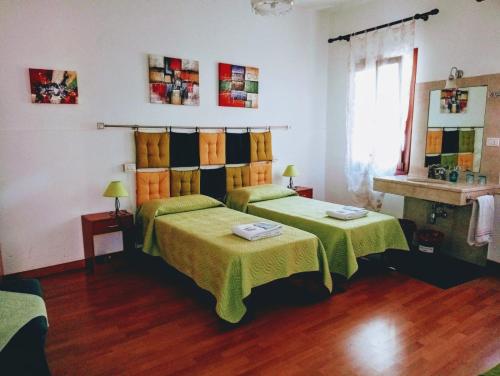 a bedroom with two beds with green and orange sheets at Casa Favaretto Guest House in Venice