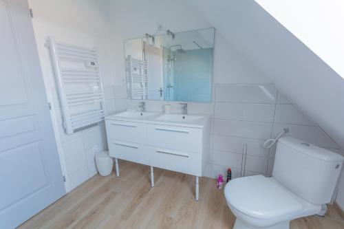 a white bathroom with a toilet and a sink at Villa Bellevue in Ambleteuse