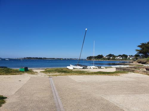 a couple of boats sitting on the sand near the water at Hôtel Glann Ar Mor in Arzon
