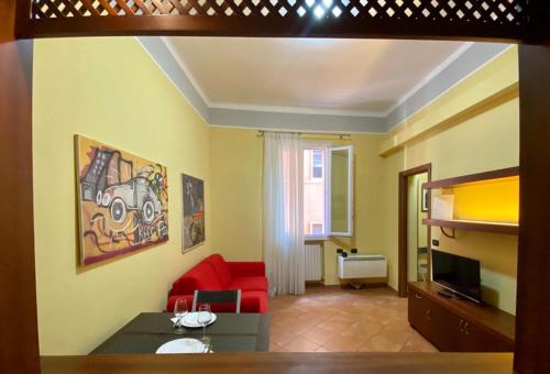 ボローニャにあるNel Sole bilocaleのリビングルーム(赤いソファ、テレビ付)
